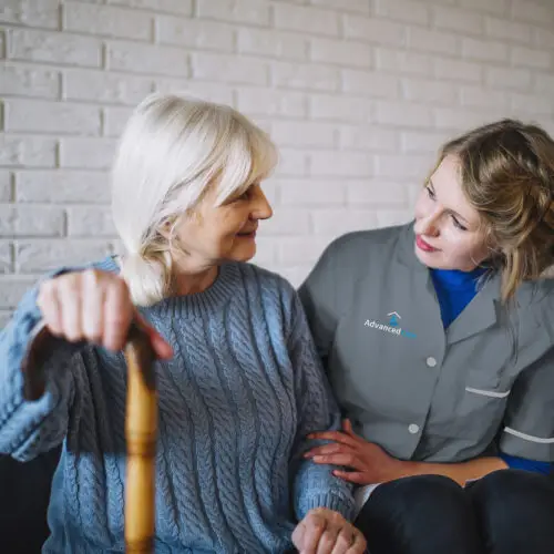 One of Advanced Care's home care assistant sitting with a service user