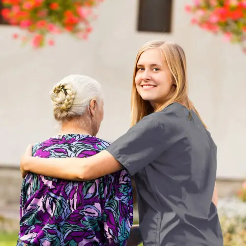 Care worker with her arms over an elderly patient's shoulder